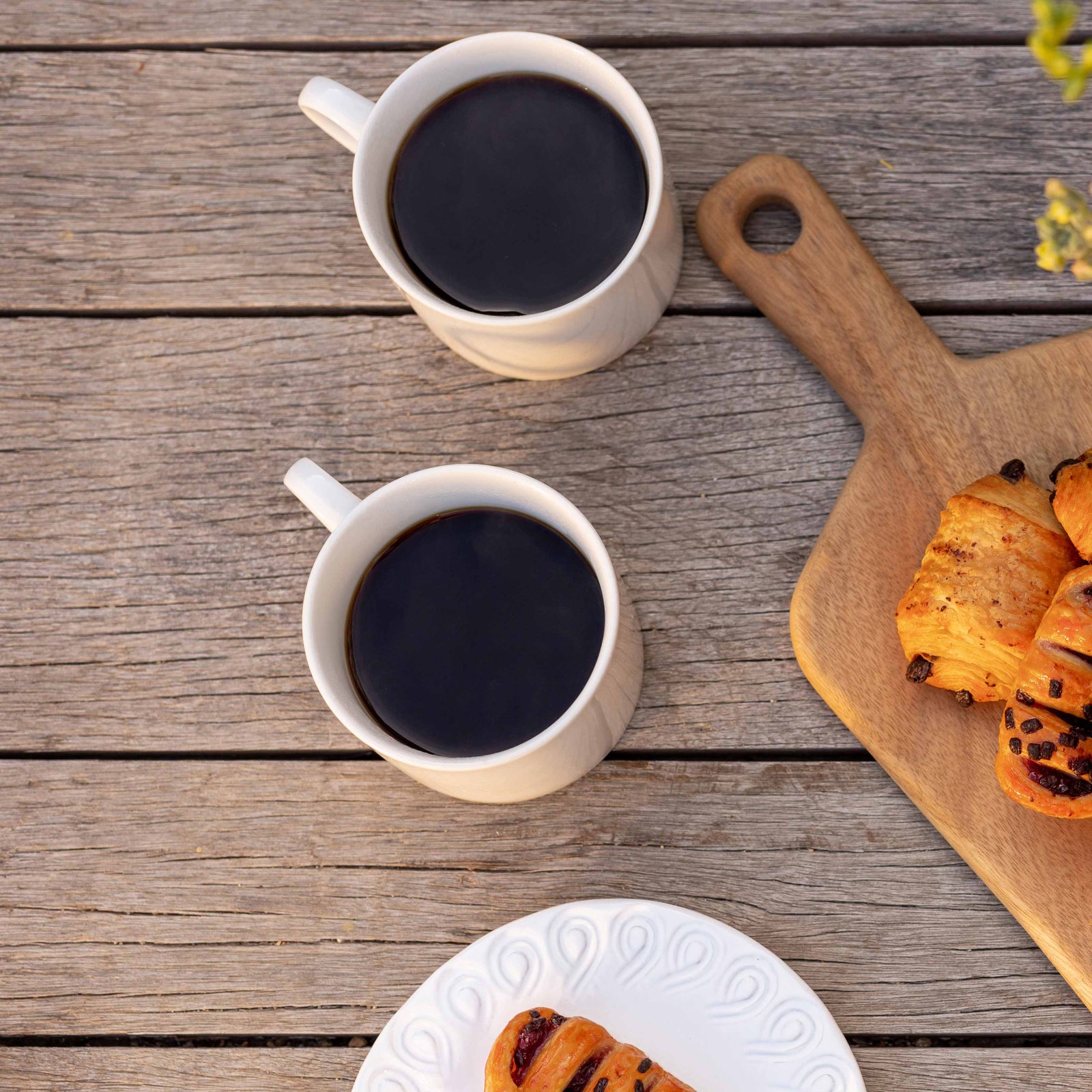 two cups of coffee and pastries on a table